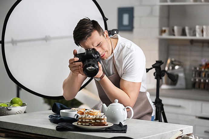 young-man-taking-picture-of-food-in-photo-studio