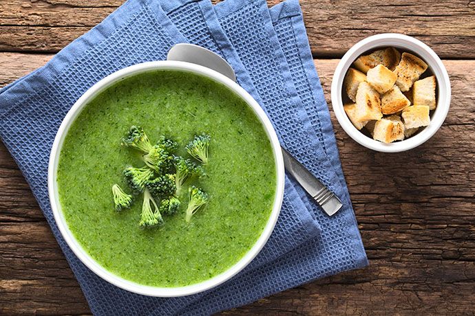 fresh-homemade-cream-of-broccoli-soup-in-bowl-garnished-with-broccoli-florets-fresh-crispy-croutons-on-the-side-photographed-overhead-selective-focus-focus-on-the-soup