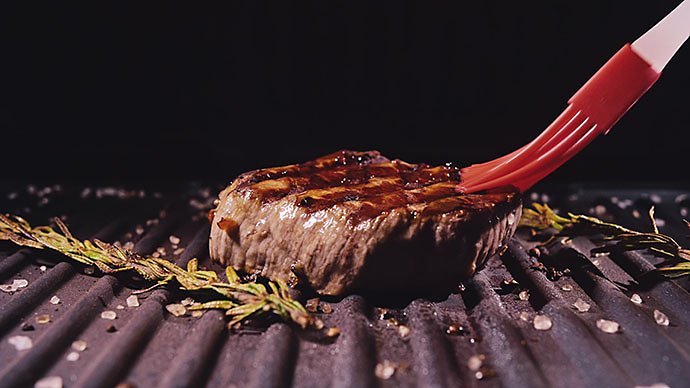 delicious-juicy-meat-steak-cooking-on-grill-prime-rare-roast-grilling-beef-electric-roaster-rosemary-black-pepper-salt-silicone-cooking-brush