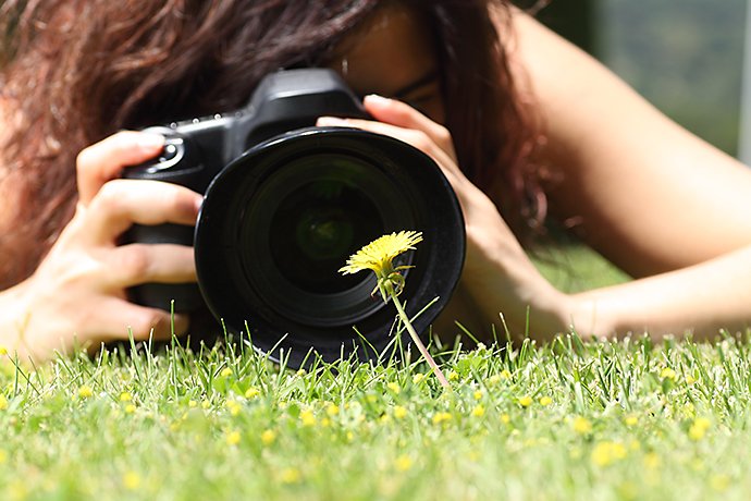 close-up-of-a-pretty-girl-taking-a-photograph-of-a-flower