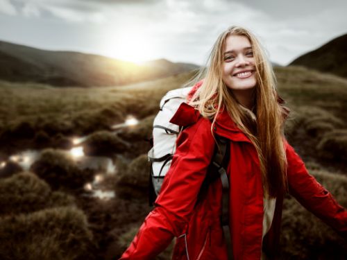 The sun and its reflections on a river behind a smiling model are focused using vignette effects