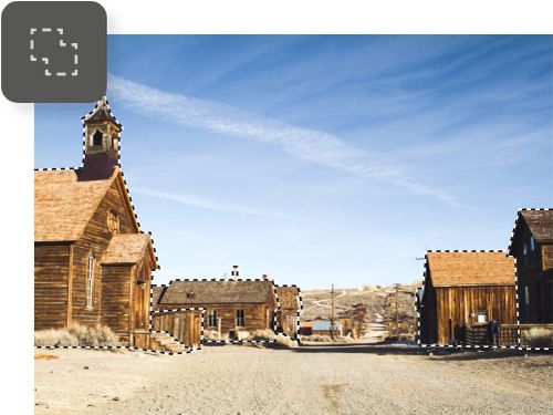 A photo of an old town with a dirt road and wood buildings. The buildings have been selected using the Lasso tool.