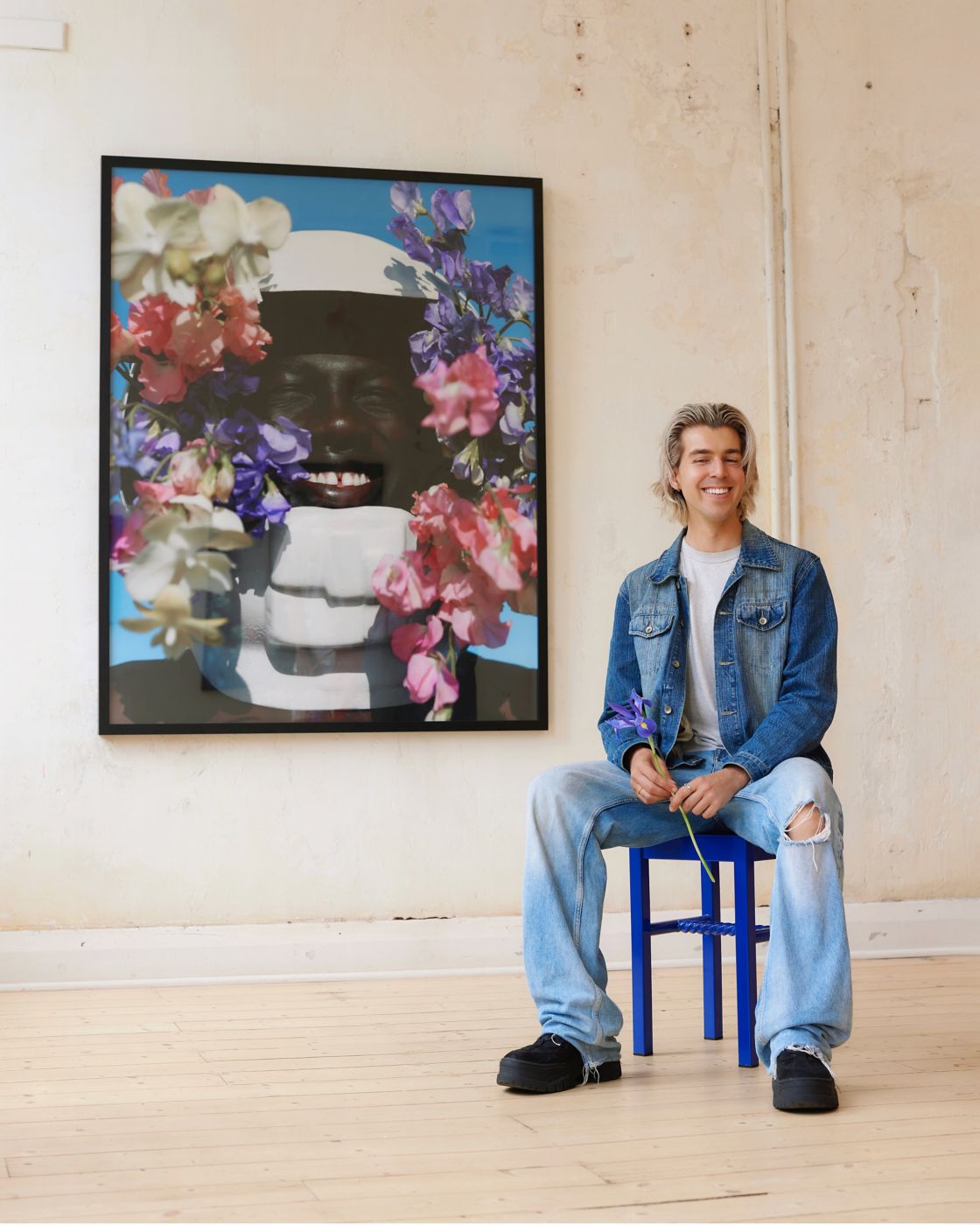 Jordan Drysdale sitting in front of one of his photographs