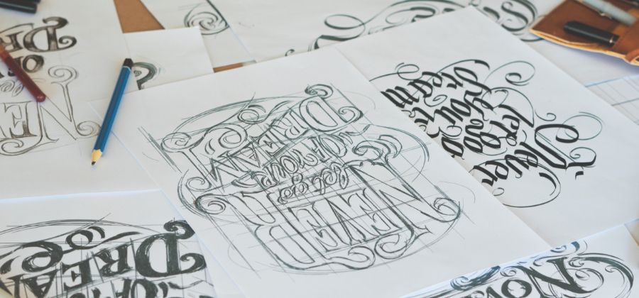 Artista practicando diferentes diseños de lettering a mano.