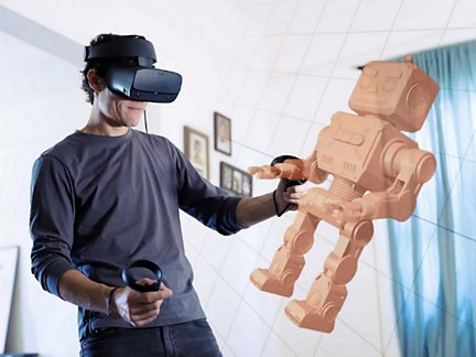Mann mit VR-Headset und 3D-Modell eines Spielzeugroboters