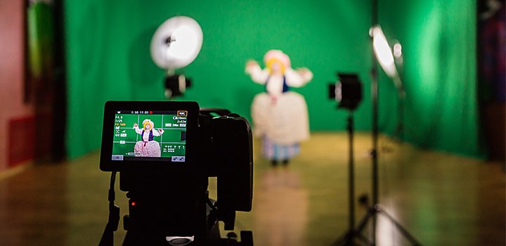 Digital film camera capturing a character performing in front of a green screen