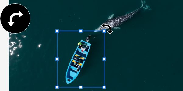 An image of a boat and a whale in the ocean. The boat has been separated into its own layer, which has a bounding box around it so that it can be rotated.