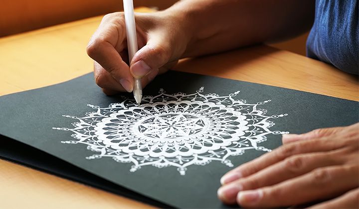 Someone drawing a mandala