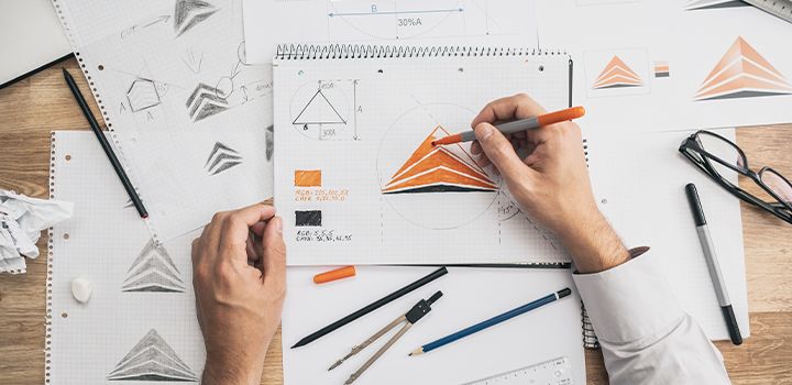 A person sketching various minimalist logo designs