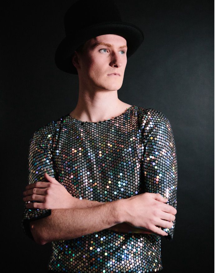A pageant contestant wearing a shiny sequin jacket posing for a photo