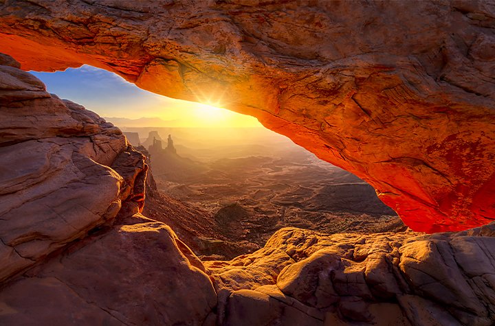 Sun shining through the opening of a desert rock landscape
