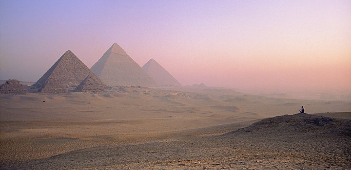Three pyramids in the desert at sunrise