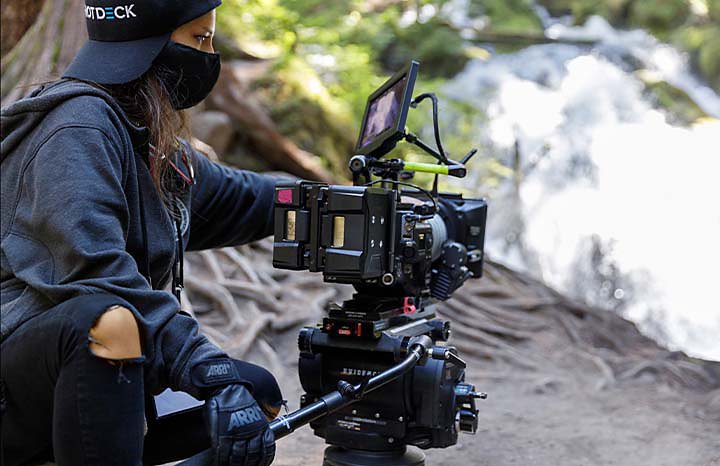 A camera operator capturing footage outdoors